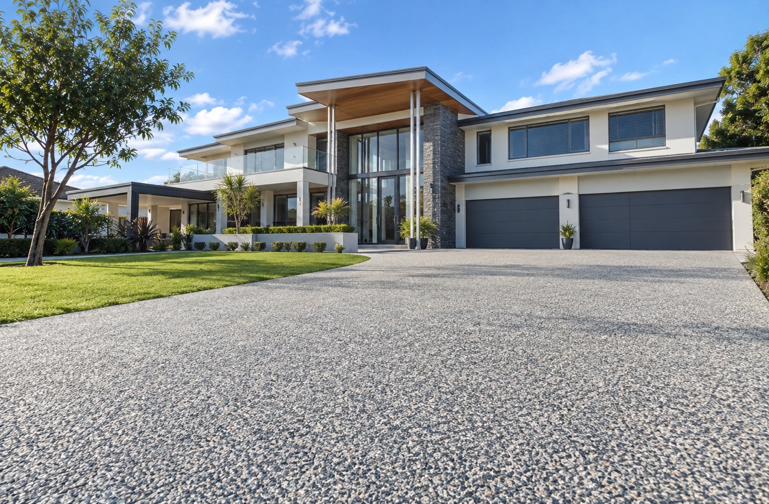Wide exposed aggregate driveway in front of a two-storey Canberra home
