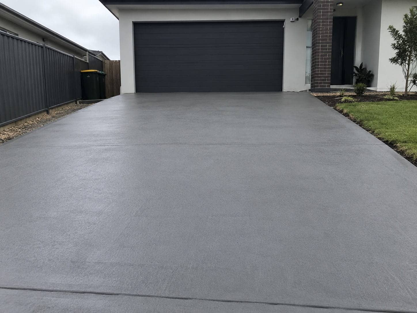 Broom-finished concrete driveway running to a garage door