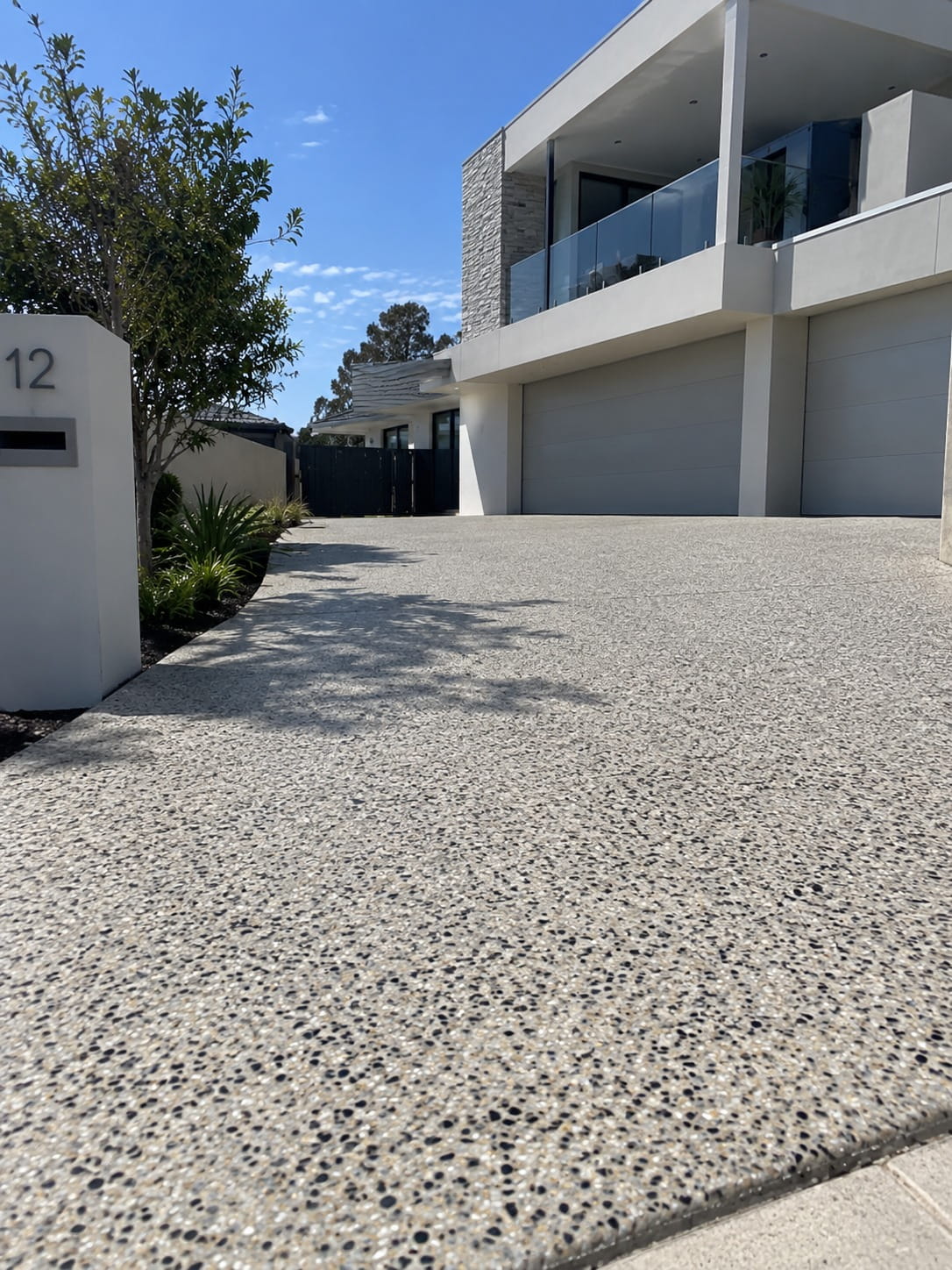 Exposed aggregate paving running alongside a two-storey Canberra home